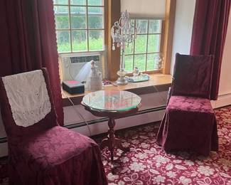 Small table with glass top and two chairs with crystal lamp