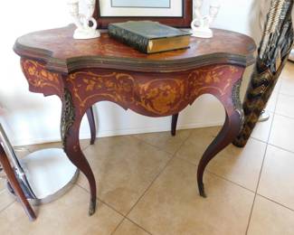 An Edwardian Marquetry Turtle Table, with complex inlay of boxwood and mother of pearl.. Conforming skirt with shaped edge and matching inlay. Cabriole legs having gilt ormulu portrait mounts.