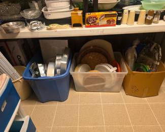 More kitchen items including cake and, miscellaneous kitchen items, platters - on floor. On table: bowls, tins, cake pans, Pyrex, salt & pepper shakers, vintage donut maker, & more!