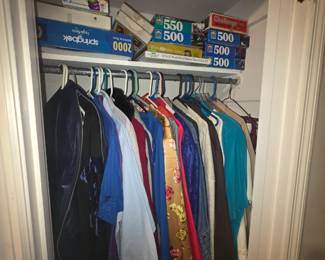 Closet full of men’s clothes - top shelf has games & puzzles