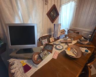 Monitor on table & clock on wall above dining set