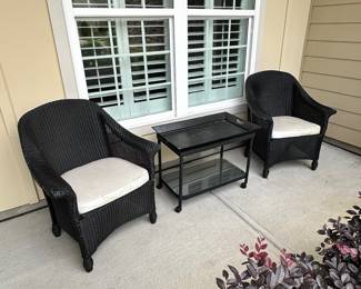 D28 - $100 Set - As is. SEE PHOTOS. Black Wicker Outdoor Set. Two Cushioned Chairs and Rolling Cart Style Table. Wicker is strong and tight. **Under the cushions are torn and need repair! The black paint does have some signs of wear around the arms. Please see photos.