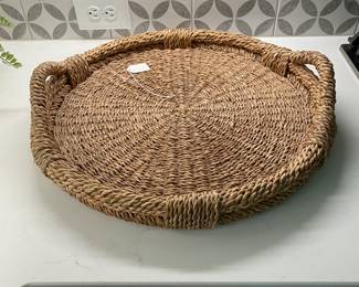 A85 - $15. Woven Tray. Measures 20" round x 4.5" tall with handles.