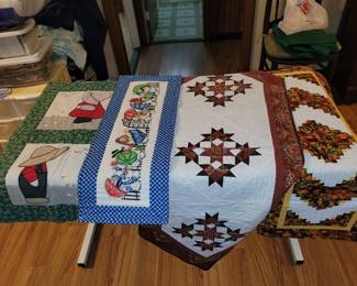 Quilted and embroidered table runners and wall hangings.