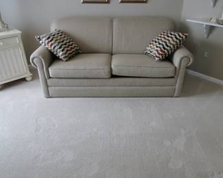 Comfortable sofa with outstanding pillows, flanking each end