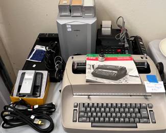 IBM Selectric typewriter (needs servicing), Sony DVD player, Subwoofer, various cords, splicer, adding machine with paper, slide boxes