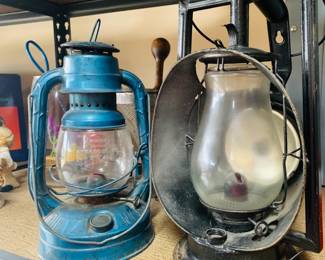 Vintage Dietz Kerosene Lanterns – Set of 2
This photo showcases two classic vintage Dietz lanterns with rich patina and timeless appeal. On the left is a blue Dietz #30 "Little Wizard," a compact and lightweight lantern known for its 23-hour burn time—ideal for emergencies or outdoor charm. Beside it sits a larger black lantern, possibly a Dietz #8 "Air Pilot," featuring a cold blast design for a brighter flame. Both lanterns offer a rustic, functional accent for collectors or farmhouse-style decor.