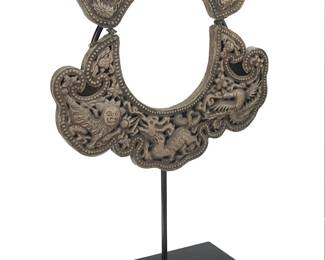 1257
20th century; Southeast Asia
A Hmong Miao collar necklace
A two-piece silver-toned metal articulated collar with incised pierced repoussé decoration of auspicious floral and faunal motifs including a dragon, lion, bird, and multiple flowers, with a custom stand
12.75" H x 13.5" W
676.5 grams gross
Estimate: $200 - $400
