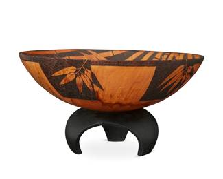 1204
Michael Patrick Smith (b. 1960)
A turned pine wood bowl, early 21st century
Etched to underside: cook pine / Hawaii / M. P. Smith / 241
The carved turned wood footed bowl depicting bamboo leaves, set in a painted carved wood stand
Bowl: 4.25" H x 12.875" Dia.; Stand: 3" H x 6.75" Dia.
Estimate: $300 - $500