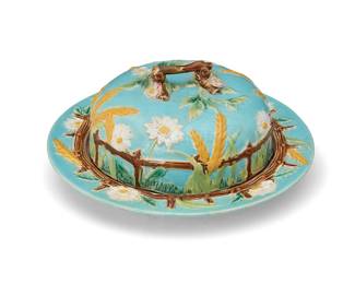1039
Late 19th/early 20th century; England
A George Jones & Sons majolica pottery covered muffin dish
With impressed backstamp: GJ / & Sons [in crescent cartouche]; further impressed: G / 2 / [cross mark]; further marked: 5205
The glazed earthenware dish and lid each depicting floral elements, a fence, and stalks of wheat in relief, featuring a figural wood lid handle
Overall: 3.25" H x 7.625" Dia.
Estimate: $300 - $500