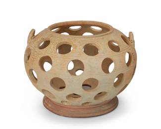 1205
20th century or earlier
A Korean Silla-style stoneware reticulated moon vessel
In the style of an early censer, the footed vessel with opposed lug handles, featuring five rows of pierced circles to body and conformingly perforated base
7.875" H x 11.5" Dia.
Estimate: $400 - $600