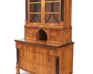 1115
20th century
A Biedermeier-style china cabinet
The dinnerware cabinet featuring ebonized columnar and trim accents, the upper console with glazed cabinet doors revealing two adjustable shelves, above opposed drawers centering an arched cavity, the lower console with three locking drawers
Overall: 80" H x 47.5" W x 24" D; Upper console: 46" H x 42.75" W x 14.75" D
Estimate: $800 - $1,200