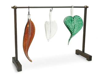 1208
Ginny Ruffner (1952-2025)
Three art glass leaf sculptures, early 21st century
Each unmarked, attributed by repute
The leaf-form sculptures, two hanging from an S-hook, each mounted to a patinated and textured metal frame
4 pieces
Longest leaf: 18.5" H x 7.25" W x 2.75" D; Frame: 23.5" H x 33" W x 10.25" D
Estimate: $200 - $400