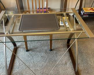 The office is very contemporary, with a glass top desk and 2 ladder bookshelves