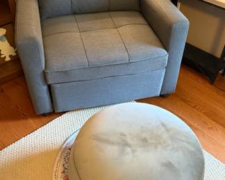 Grey upholstered accent chair with velvet storage footstool