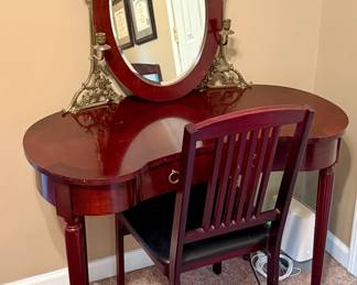 Bombay style vanity and chair with oval mirror and brass candlestick accents