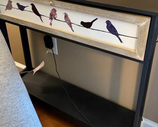 Black sofa table with painted birds on faux drawer