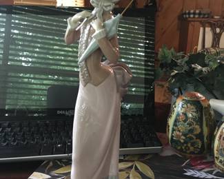 Lladro "Coquetry," model number 4995. This retired Lladro figurine depicts a woman with a refined posture, holding an umbrella. There are a few different kinds of these figurines.
