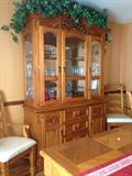 Large pine breakfront, 2 dining arm chairs, and corner of dining table