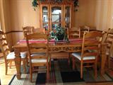 Lovely large pine dining table with one leaf in with 6 side chairs and 2 arm chairs, (has custom wood pads) and matching pine breakfront
