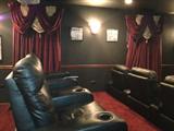 Second row of triple theater seating and custom window treatments