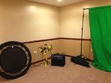 Chromakey vdeo green screen set up with carrier, small single trampoline, karaoke machine, and small light system