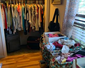 Packed closet of blouses, men’s sport shirts, sweaters and sweatshirts! And a table stacked with Tshirts, tank tops, lingerie, and swimwear