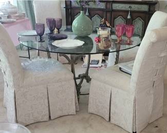 Heavy iron with round glass top dining table with 4 cream parsons chairs