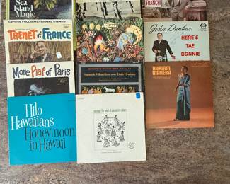 Includes a collection of vintage vinyl records from the 1960s and 1970s, featuring genres such as folk, world music, and educational records. Notable titles include 'Modern Spanish,' 'Hilo Hawaiians Honeymoon in Hawai'i,' and 'Here's Tae Bonnie.' See pictures for more details.