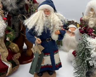 This charming auction lot features a collection of vintage Santa figurines from the TJ Collection. The set includes three intricately designed Santa dolls, each dressed in unique attire. The tallest Santa, dressed in a blue coat, holds gifts and measures approximately 12 inches. Another Santa wears a red gown with festive embellishments and stands about 10 inches tall. The third figure showcases a whimsical design with a furry coat. These collectibles are perfect for holiday decor or as gifts.