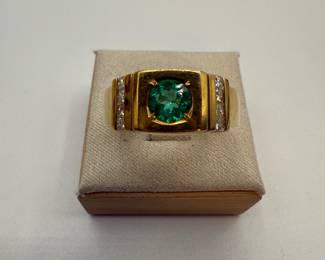 this is an 18 karat gold ring with eight .06 princess cut diamonds and a green stone that measures at 6.2 mm. Weight is shown both Troy ounces and in grams. The ring is a size 11
