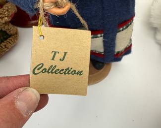 This charming auction lot features a collection of vintage Santa figurines from the TJ Collection. The set includes three intricately designed Santa dolls, each dressed in unique attire. The tallest Santa, dressed in a blue coat, holds gifts and measures approximately 12 inches. Another Santa wears a red gown with festive embellishments and stands about 10 inches tall. The third figure showcases a whimsical design with a furry coat. These collectibles are perfect for holiday decor or as gifts.