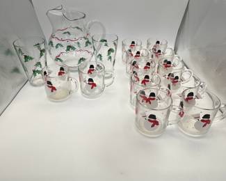Includes a 1980s pitcher and sixteen glasses featuring a playful snowman design and holly accent. Perfect for festive gatherings.