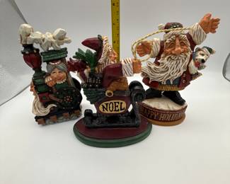 David Frykman Santa Figures. Included are: a whimsical Santa with a 'NOEL' sign, a festive Santa with a puppy, and a cheerful Mrs. Claus with gift-laden sled. Each piece captures the joy of the holiday season.