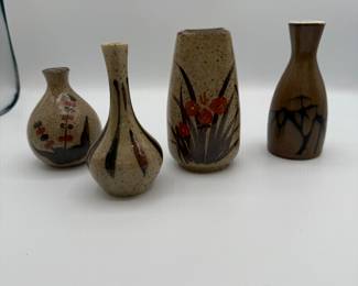 A collection of three handcrafted vases, featuring distinctive designs and earthy tones. Includes one tall vase with engraved flowers, a narrow decorative vase, and a brown bottle-shaped vase with a unique pattern. Estimated year of production is mid-20th century. Each piece is marked as handcrafted.