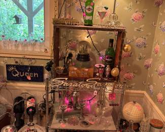 Our fella was into martinis and had quite a few bar items in both of the kitchens that are in this house. This is just a small display, showcasing some of the items. That’s a collectible martini glass light on the top shelf! Plus some of the vintage auto metal decals