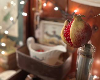 This ornamental pomegranate is sitting a top an odd glass item that we have not been able to figure out where it comes from. Maybe one of you guys will know…