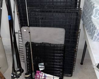 Three different sizes of folding dog kennels and some fishing poles.