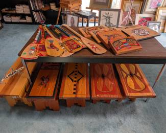Some of the many benches that are hand painted with unique designs on each one. Each bench has information about the design and origin on the bottom. Paddles and wall hangers available as well