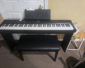 Digital piano with weighted keys and piano bench.