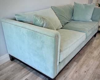 Turquoise tuxedo-style sofa with nailhead trim and matching throw pillows