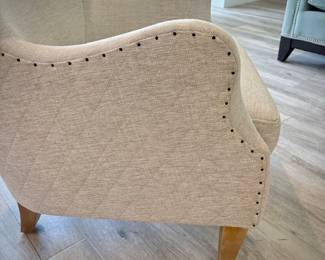 Off-white high-back armchair with nailhead trim