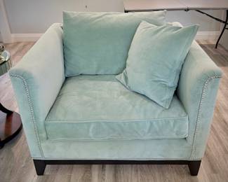 Turquoise tuxedo-style armchair with nailhead trim and matching throw pillows