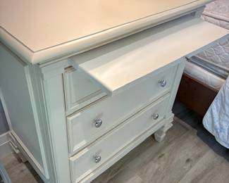 One of two white night stands, each with three drawers and pullout tray