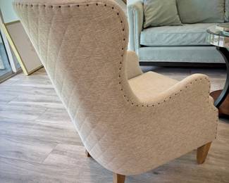 Off-white high-back armchair with nailhead trim