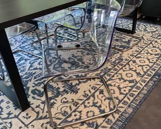 H84 - $475 SET. Ikea Tranebo Dining Table. Measures 36.5" wide x 87" long x 30" tall. Overall very good condition - does have some surface marks. 6 Ikea Tobias Clear & Chrome Plated Chairs. 5 are in very good condition. 1 has a crack - still useable.
