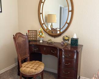 Oval Federal-style wall mirror, giltwood frame. Mahogany nine drawer keyhole desk.