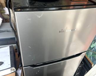 medium sized mini fridge with freezer and coffee. machine