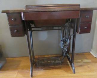 Singer sewing machine. Treadle machine has been removed and replaced by more modern electric machine.