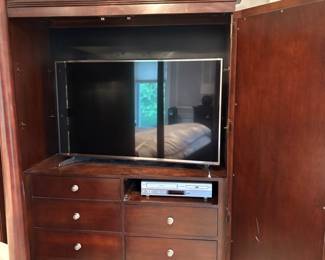 A classic Armoire dresser with a modern twist. Made from maple solids, it has a dark cherry finish and brushed steel hardware. The dresser features six drawers and has optional shelving above. W55 1/4 x H79 1/4 x D25 1/4 in